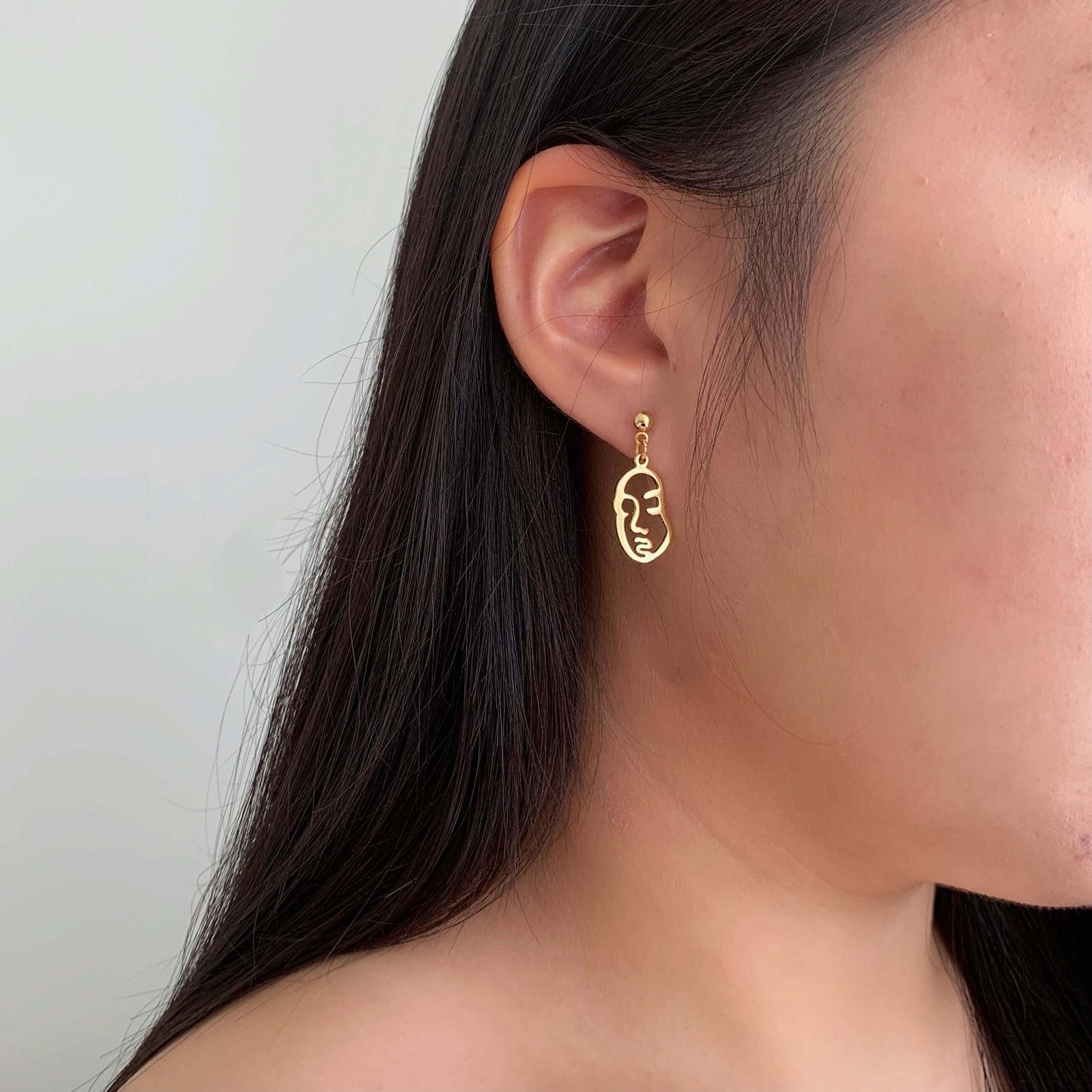 gold abstract face charm earrings
